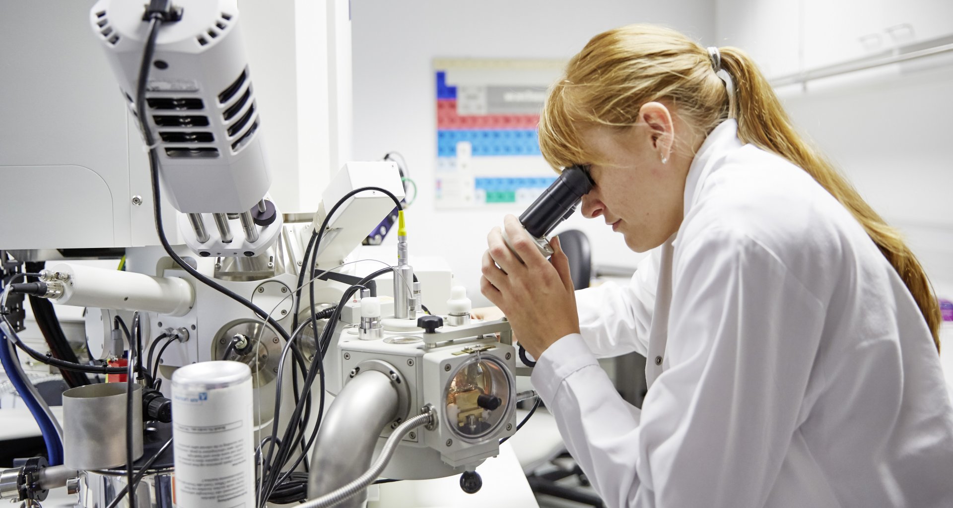 Frau an einem Mikroskoparbeitsplatz